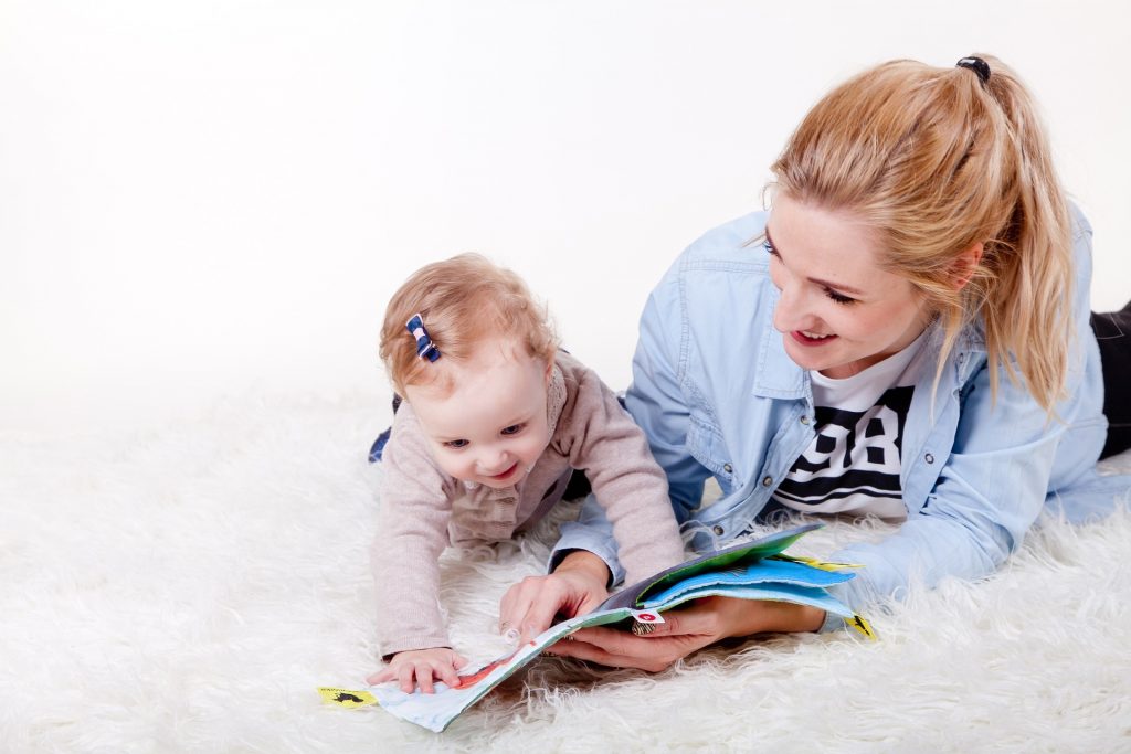 Mamá fomentando la lectura infantil en su hija